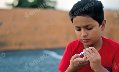 Preview: Boy Concentrating on Clipping His Fingernails Outdoors