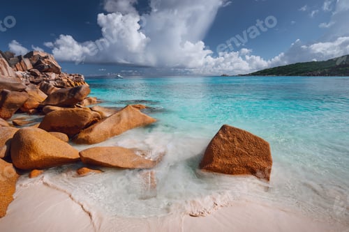 Preview: Grand anse, La Digue island, Seychelles. Sandy beach with orange granite boulders and azure ocean