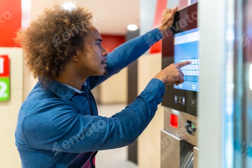 Preview: Young man using interactive touchscreen vending machine