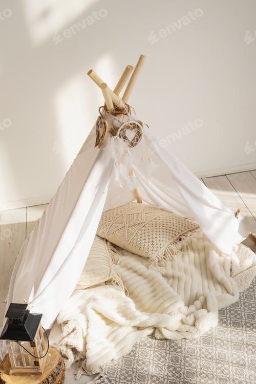 Preview: White fabric wigwam and Native American decor in a children's room on a sunny day.