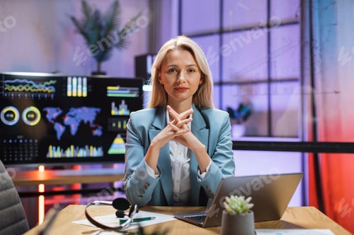 Preview: Business woman sitting at office desk with papers and laptop