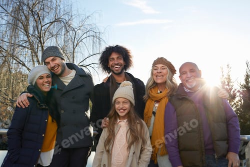 Preview: Multi generational family wearing coats and knit hats looking at family smiling