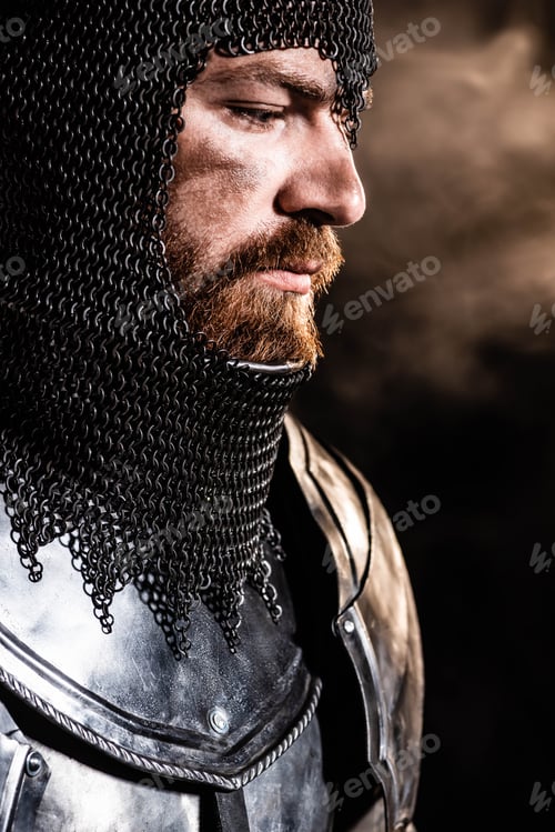 Preview: handsome knight in armor looking away on black background