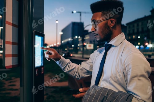 Preview: Businessman using digital information system at bus stop, Milano, Lombardia, Italy