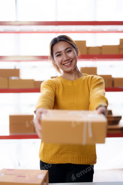 Preview: Young Asian online business owner woman is preparing a parcel box to prepare the package