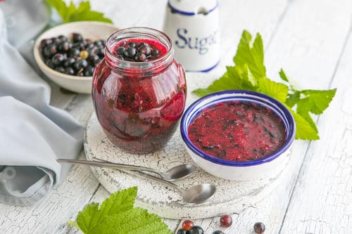Preview: fresh currant jam with shugar. Fresh berries black currant on white wooden background.