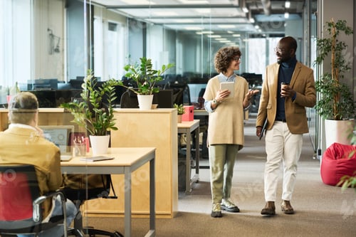 Preview: Woman with tablet and her colleague with coffee talking in coworking space