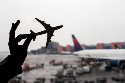 Preview: Silhouette of a small airplane model on airport background