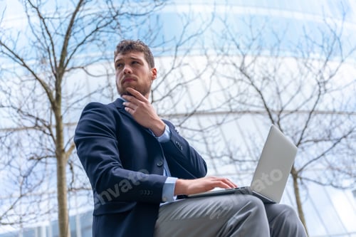 Preview: Young businessman or finance man thinking before entering the meeting, glass building