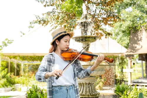 Preview: portrait of Young Asia woman music violinist play violin, relax in the garden with peace of mind