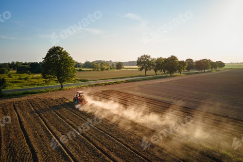 Preview: Tractor working in agricultural field, cultivating and plowing dry soil