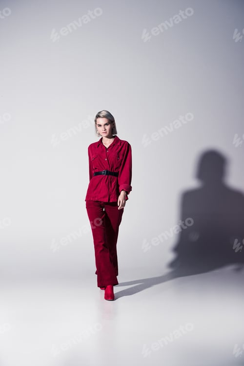 Preview: attractive elegant girl in red trendy clothes posing for fashion shoot, on grey