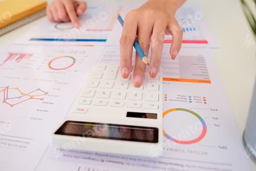 Preview: Close up of businessman or accountant hand holding pencil working on calculator to calculate