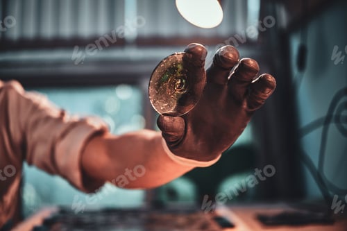 Preview: Closeup photo shoot of man's hand holding peace of colourful glass.