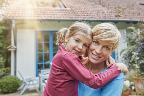 Preview: Portrait of smiling mother carrying daughter in front of their home