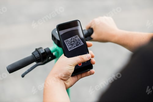 Preview: Man scan QR code by smart phone to unlock and rent electric push scooter on street.