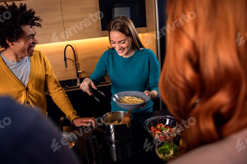 Preview: Group of friends having dinner party at home drinking wine and eating vegetarian food.