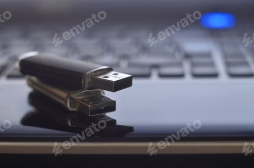 Preview: USB flash cards lying on black laptop case in front of his keyboard