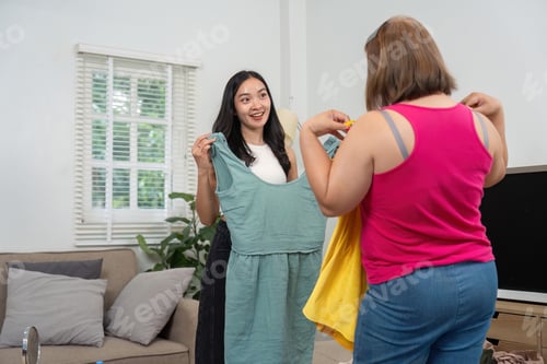 Preview: Friends explore new outfit ideas while giggling and enjoying each other’s company at home.