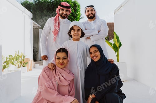 Preview: Emirati family standing together smiling in traditional attire