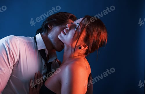 Preview: Beautiful man with his hot girlfriend is in the studio with blue neon lighting. Couple in love