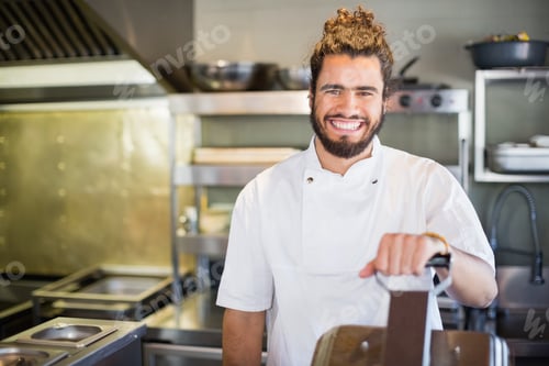 Preview: Smiling male chef standing in commercial kitchen