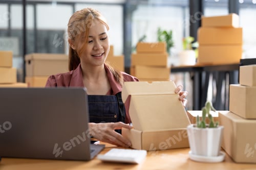 Preview: Young woman small business owner working at home office. Online marketing packaging delivery