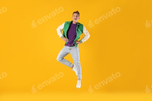 Preview: Man in stylish outfit jumping on orange background
