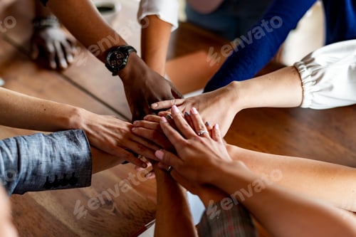 Preview: Hands joined over wooden table
