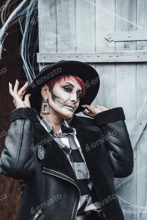 Preview: Scary woman, girl celebrating halloween.Terrifying black skull half-face skeleton makeup and witch c