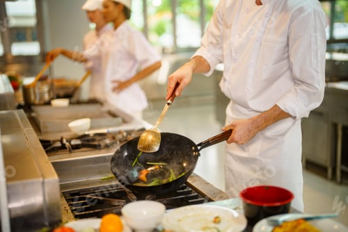 Preview: Professional chef cooking vegetables in a wok on a commercial kitchen stove with steam rising