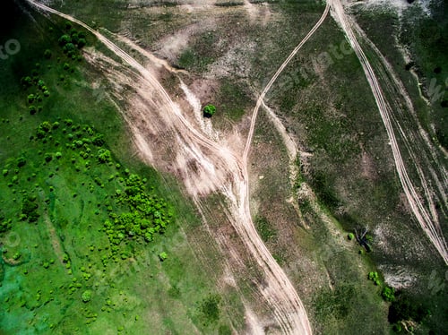 Preview: aerial photo of green field with trees and rolled roads