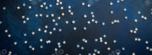 Preview: White and blue small stars of sweets on a dark blue concrete or stone background. Selective focus. C