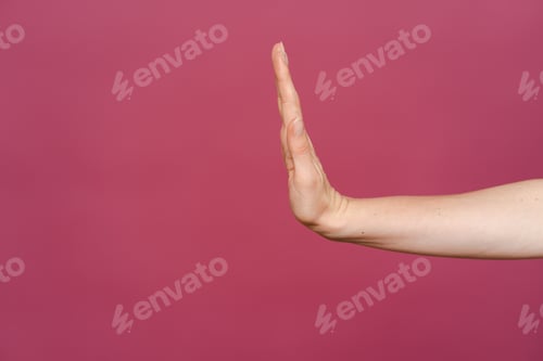 Preview: Women hand showing stop sign on a pink background