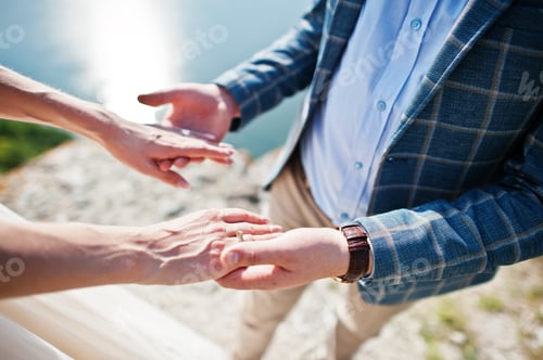 Preview: Handsome groom holding his wife's hands on their wedding day.