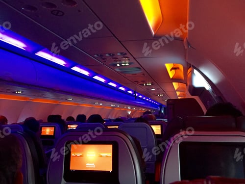 Preview: Interior of an airplane illuminated in orange and purple lights.