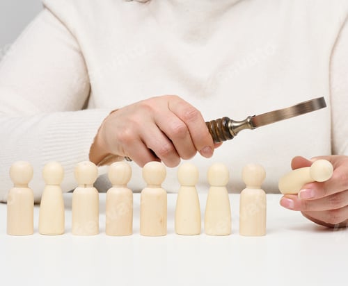Preview: Woman holding a magnifying glass and wooden men on a white table. Personnel recruitment concept