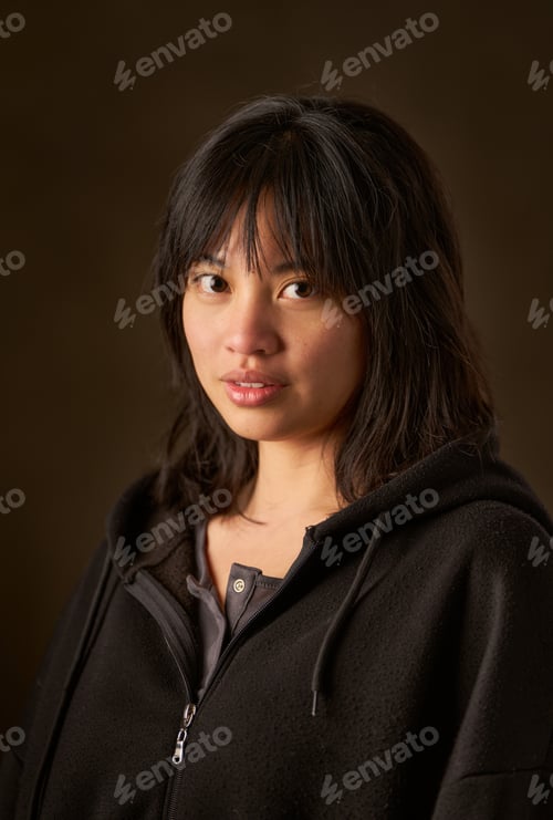 Preview: Young asian woman posing in studio with dark background