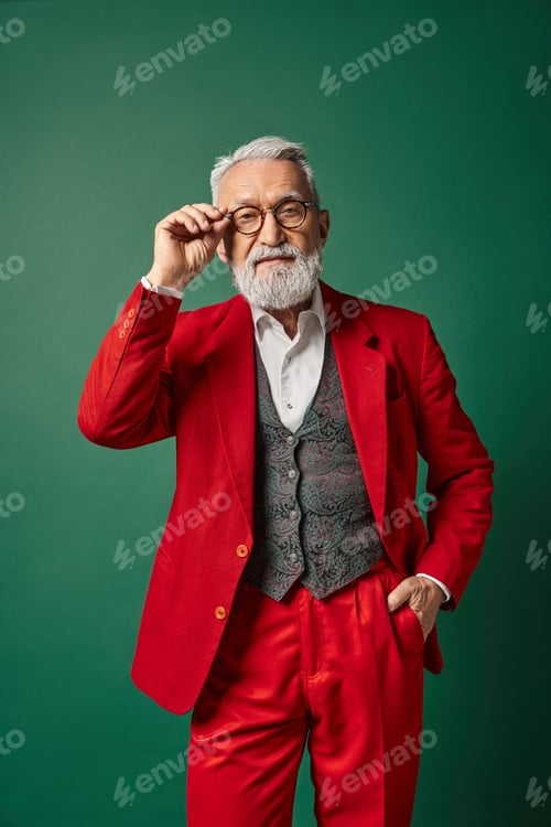 Preview: elegant classy Santa with white beard and glasses posing with one hand in pocket, winter concept