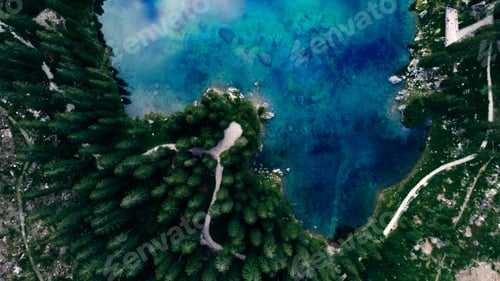 Preview: Aerial view of an azure lake close to the coast covered with fir tree forests