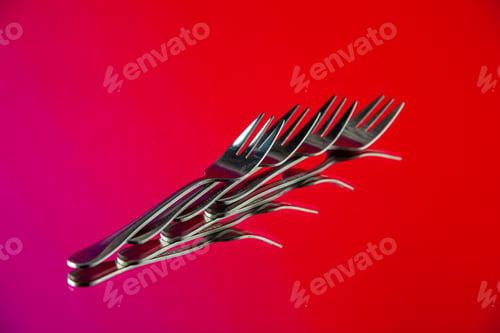 Preview: front view metal forks lined on pink-red background cutlery kitchen food color photo table dinner