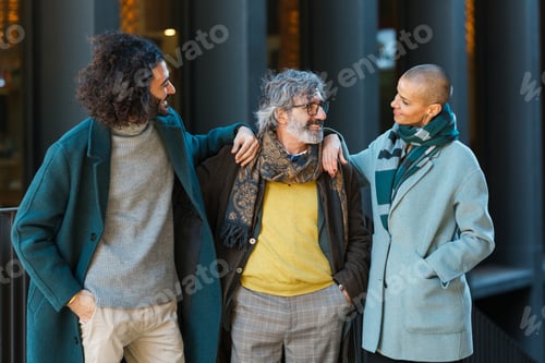 Preview: Business people looking at each other and smile while standing together outdoors on the street