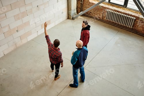 Preview: Engineers discussing quality of materials while one of them pointing at wall