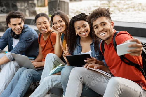 Preview: Group of international students taking photo together outdoors on smartphone