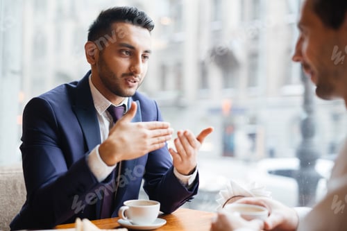 Man in Suit Discussing Business Over Coffee