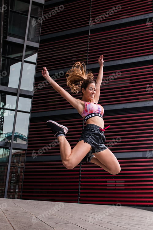 Preview: Cheerful happy sportswoman jumping up