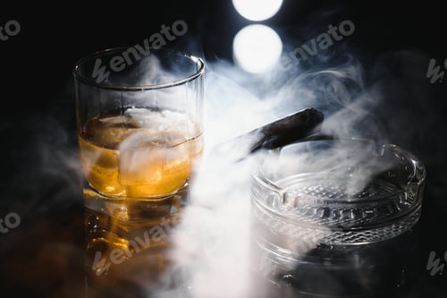 Preview: A glass of whiskey or Bourbon with ice cubes and a cigar on a black slate with smoke