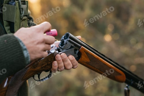 Preview: Hunter man loading his gun while hunting outdoors