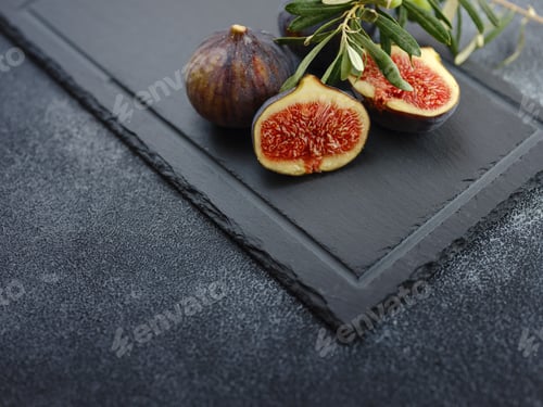 Preview: fresh ripe figs fruit and olive branch on dark table