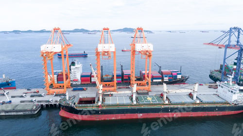 Preview: crane loading cargo container from truck to container ship in the international